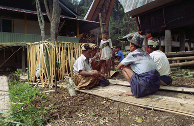 Officiants au nord-est de la maison., Officiants northeast of the house. (anglais), Pemangku adat di sebelah timur laut rumah. (indonésien) la vignette