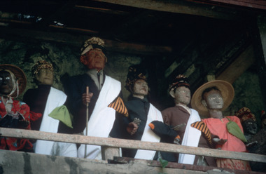 Tau-tau in front of a burial site., Statuettes d'ancêtres (tau-tau) devant un lieu de sépultures. (French), Patung tau-tau para leluhur, depan makam. (Indonesian) thumbnail