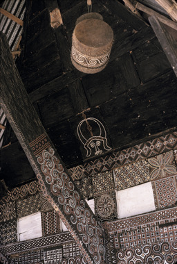 Tambour suspendu sur la façade d'une maison., Drum hanging from façade of a house. (anglais), Digantungkan di bagian depan rumah. (indonésien) la vignette