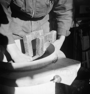 Place de la Mairie. Fabrication d'un tambourin dans l'atelier de Marius Fabre. Dans le petit atelier : collage de la pièce pour renforcer les "réganches" (poignées) la vignette