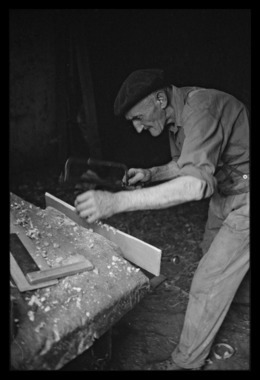 Léonce Mano dans son atelier confectionnant un rhombe. Découpage des dents sur l'autre face la vignette