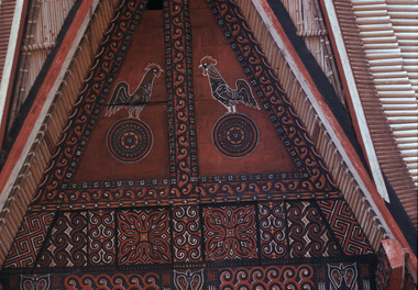 Cocks engraved on the gable of a house., Coqs gravés sur le pignon d'une maison. (French), Ukiran ayam jantan pada wajah depan sebuah rumah adat. (Indonesian) thumbnail