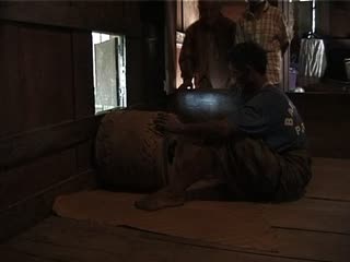 VIDEO: The deceased’s son beats the drum, sitting facing West, To' Barana', 2000., VIDEO : Le fils du défunt frappe le tambour, assis face au couchant, To' Barana', 2000. (French), Anak dari mendiang menabuh gendang, duduk dalam rumah, menghadap ke sisi matahari terbenam, To’ Barana’, 2000.  (Indonesian) thumbnail