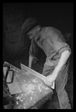 Léonce Mano dans son atelier confectionnant un rhombe. Découpage des dents sur une face la vignette