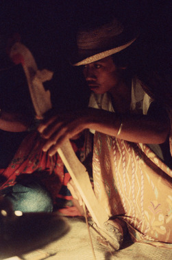 Geso’-geso’ fiddle player during the pakorong ritual at Pa'Buaran, 1993. The head of the instrument is in the form of a cock., Joueur de vièle geso'-geso' lors du pakorong à Pa' Buaran, 1993. La tête du manche est en forme de coq. (French), Pemain alat dawai gesek geso’-geso’ pada saat ritus pakorong di Pa’ Buaran, 1993. Kepala gagangnya berbentuk ayam jantan.  (Indonesian) thumbnail
