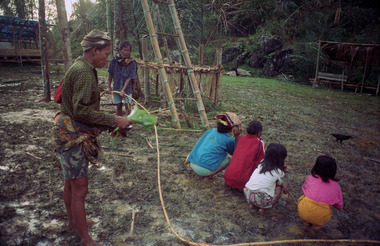L'officiant fait faire le tour du champ aux officiées, bua' kasalle, Bamba (Deri), 1993., The burake takes the ‘officiated’ women round the field. Bua’ kasalle, Bamba (Deri), 1993. (anglais), Pemangku adat burake meminta kepada para petugas untuk berkeliling di sekitar arena, ritus bua’, Bamba, Deri, 1993. (indonésien) la vignette