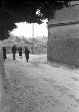 Femme portant une cape et une coiffe noire à la sortie de la messe (French) thumbnail