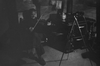 M. Edouard Courroux jouant du violon dans sa cuisine. la vignette
